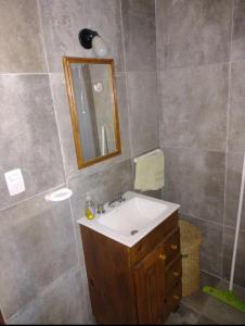 een badkamer met een wastafel en een spiegel bij Cabaña de piedra Los Crespines in San Antonio de Arredondo