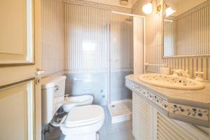 a white bathroom with a toilet and a sink at Villa Carla, a charming villa in the center of Taormina in Taormina +25 photos