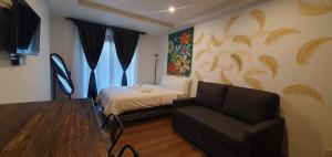 a bedroom with a bed and a couch and a chair at JCGA Apartments at Megatower Residences IV - Near SM & Session Rd in Baguio