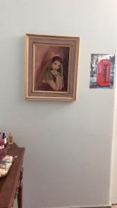 a painting of a woman is hanging on a wall at private room in the heart of Athens 2 in Athens