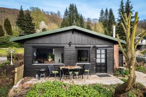 uma pequena casa preta com uma mesa e cadeiras em Haus Dina em Bodenwerder