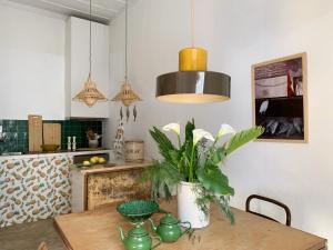a kitchen with a table with a vase on it at Farmacia Beach House in Odemira