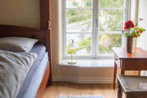 a bedroom with a bed and a window with a lamp at Møllehusets Bed & Breakfast in Nordborg