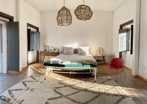 a bedroom with a bed and a red chair at Farmacia Beach House in Odemira
