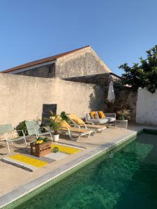 a pool with chaise lounge chairs and a swimming pool at Farmacia Beach House in Odemira