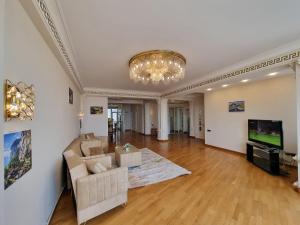 uma sala de estar com um lustre e um sofá em Central sea view em Baku