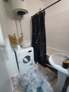 a bathroom with a washing machine and a sink at Уютная квартира in Taraz