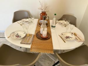 einen weißen Tisch mit Tellern und Weingläsern darauf in der Unterkunft Monastir Bord de Mer Palais Présidentiel in Monastir
