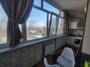 a room with a window with a view of a kitchen at Уютная квартира in Taraz