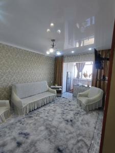 a living room with two beds and a couch at Уютная квартира in Taraz