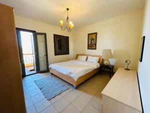 Schlafzimmer mit einem Bett und einem Kronleuchter in der Unterkunft Tala bay aqaba one bedroom nice view in Al Burj