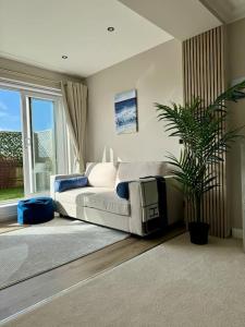 sala de estar con sofá blanco y planta en 3 bed Garden Apt, Clifftop, sleeps 8 with parking and Lazy Spa, en Southbourne 23 fotos más