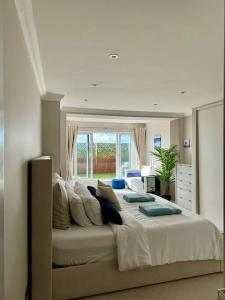 Un dormitorio con una cama grande con ventana. en 3 bed Garden Apt, Clifftop, sleeps 8 with parking and Lazy Spa, en Southbourne