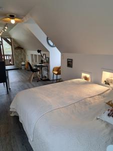 Schlafzimmer mit einem großen weißen Bett und einem Schreibtisch in der Unterkunft O loft des Croisiens in Saint-Quentin-Lamotte-Croix-au-Bailly
