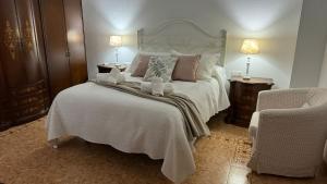un dormitorio con una cama con dos animales de peluche en Casa Rural Las Camelias, en Herrera del Duque