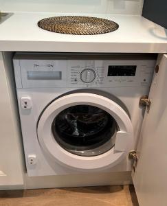 uma máquina de lavar roupa branca debaixo de um balcão numa cozinha em Superbe appartement avec Terrasse Jardin et Parking privé em Saint-Tropez