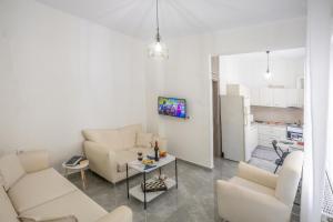 a living room with two couches and a kitchen at House & Garden in Kavála