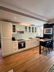 uma cozinha com armários brancos e uma mesa de madeira em Superbe appartement avec Terrasse Jardin et Parking privé em Saint-Tropez