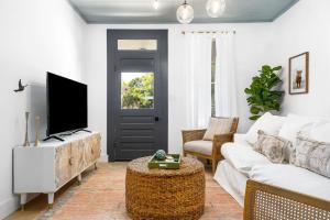 Una sala de estar con un sofá blanco y un televisor. en The Birdhouse - Hot Tub Pool & Fire Pit, en Fredericksburg