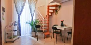 Habitación con mesa, sillas y escalera. en Donna Rosa - Main Avenue en Taormina