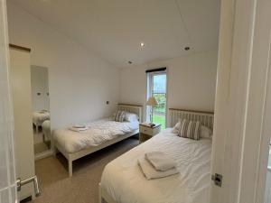 a bedroom with two beds and a window at Remarkable 3-Bed Lodge in Honiton in Honiton