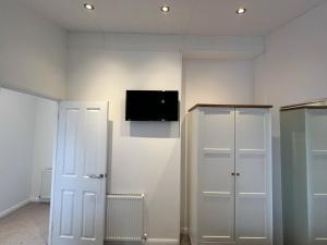 a room with two white doors and a tv on the wall at Remarkable 3-Bed Lodge in Honiton in Honiton