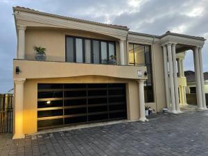 a house with a large garage door in front of it at Rental house in Bluewater Bay in Gqeberha