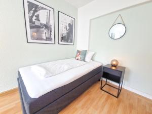 - un petit lit dans une chambre avec 2 photos sur le mur dans l'établissement Apartment am Dammtor, à Hildesheim