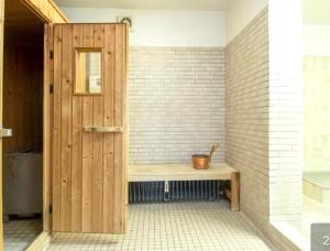 łazienka z drewnianymi drzwiami i ławką w obiekcie Ostsee Küstenliebe Grömitz w mieście Grömitz