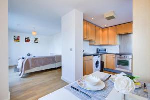 a kitchen with wooden cabinets and a table with dishes on it at Pass the Keys Stratford Home to Home in London