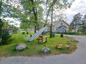 a statue of a surfboard on the grass in front of a house at Kansakoulu in Västanfjärd