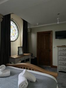 1 dormitorio con cama, escritorio y ventana en St Nicholas Boutique Hotel en Shrewsbury