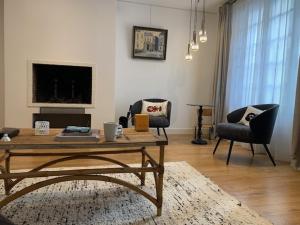 a living room with a coffee table and two chairs at Normandy chérie in Trouville-sur-Mer