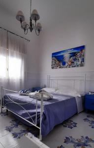 een slaapkamer met een bed met een blauw dekbed bij Il Sole e l'Azzurro in Marina di Lizzano