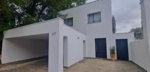 een wit huis met een garage en een gebouw bij Pousada Santiago Morumbi in Sao Paulo