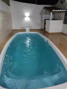 uma grande piscina com água azul num quarto em Casa ampla e agradável com piscina e churrasqueira em Juazeiro