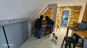 two people standing at a table in a kitchen with a dog at MADAME in Clérey