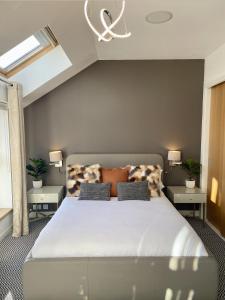 een slaapkamer met een groot wit bed en 2 tafels bij Edinburgh Penthouse 101 in Edinburgh