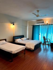 1 dormitorio con 2 camas y ventilador de techo en AP's Castle Stay en Kharadi