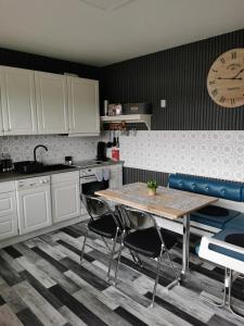 cocina con mesa y reloj en la pared en Sabrina's Ferienwohnung, en Hammelburg