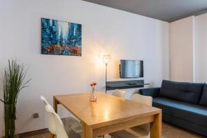 a living room with a wooden table and a blue couch at Staycity Apartments Sukiennice 6 in Wrocław