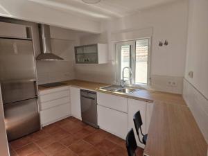 a kitchen with white cabinets and stainless steel appliances at Casa Las Tejeras in Casavieja