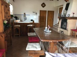 cocina con mesa de madera y chimenea en le Mirador, en Courzieu