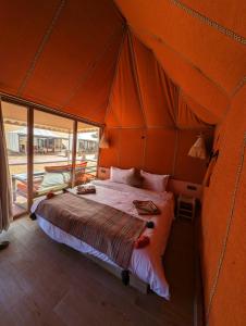 1 dormitorio con 1 cama en una tienda de campaña en Merzouga Dunes Luxury Camps, en Merzouga