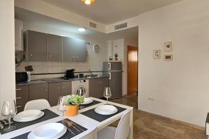 a kitchen with a table with plates and wine glasses at Romántico apartamento céntrico in Málaga