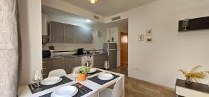 a kitchen with a table and chairs and a kitchen with a counter at Romántico apartamento céntrico in Málaga +5 photos