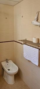 a bathroom with a sink and a toilet and towels at Romántico apartamento céntrico in Málaga