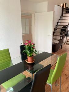 uma sala de jantar com uma mesa de vidro e cadeiras verdes em Appartment23 em Karlsruhe