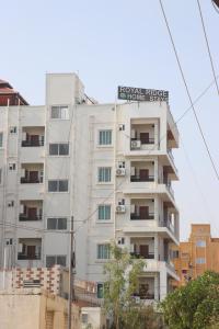 a tall white building with a sign on it at ROYAL RIDGE HOME STAYS in Tirupati