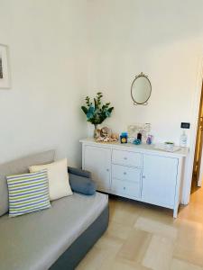 Eden Apartment في اناكابري: غرفة معيشة مع أريكة وخزانة بيضاء